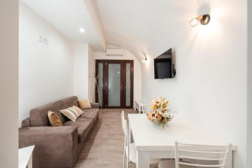 ein Wohnzimmer mit einem Sofa und einem Tisch in der Unterkunft Le Balille - Po in Santeramo in Colle