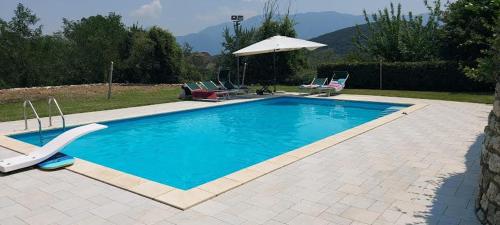 - une piscine avec des chaises et un parasol dans l'établissement B&b Stazione La Reggia, à Caserte