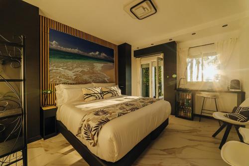 1 dormitorio con 1 cama grande y una pintura en la pared en HOSTAL LUXURY NIT I DIA, en Altea