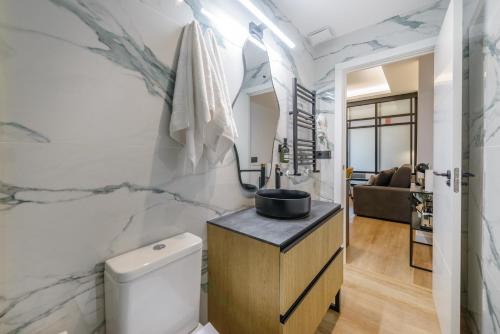 un bagno con un lavandino e un water in una stanza di GRAN VIA capitals by MONARO***** a Madrid