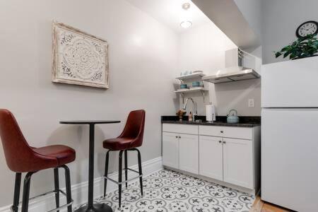 a kitchen with two chairs and a table and a refrigerator at City Nest in FAN Museums Free Parking in Richmond