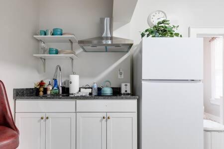 a kitchen with white cabinets and a white refrigerator at City Nest in FAN Museums Free Parking in Richmond