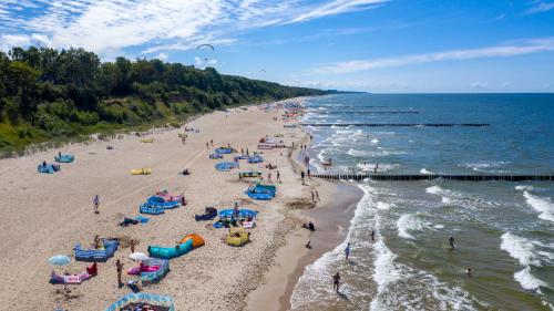 a beach with a bunch of people on the sand at Aparthouse Cliff by Orka in Trzęsacz