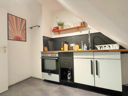 a kitchen with a black and white stove top oven at Über den Dächern von Witten bis 6P in Witten