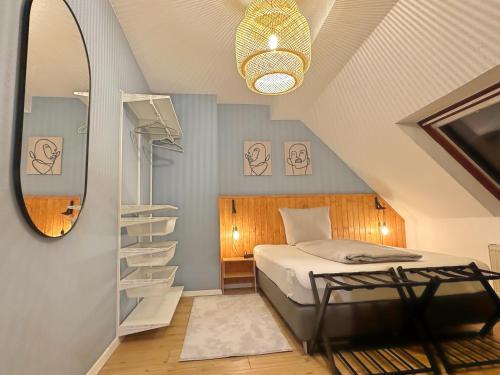 a attic bedroom with a bed and a mirror at Über den Dächern von Witten bis 6P in Witten