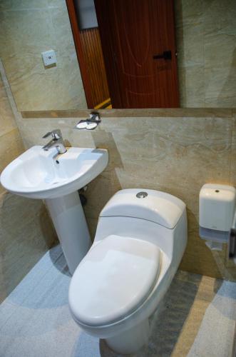 a bathroom with a toilet and a sink at Hotel ByHours Las Américas in Bogotá