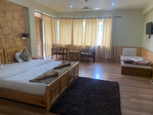 a bedroom with a large bed and a living room at Adu's Eternal Comfort in Leh