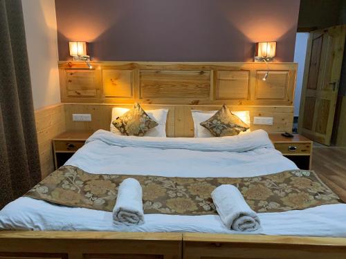 a bedroom with a large bed with two lamps on it at Adu's Eternal Comfort in Leh