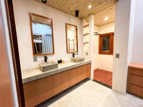 uma casa de banho com dois lavatórios e dois espelhos em Jurema Dourada em Beberibe