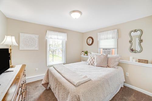 a white bedroom with a bed and a window at Jerry's Way in Lake George