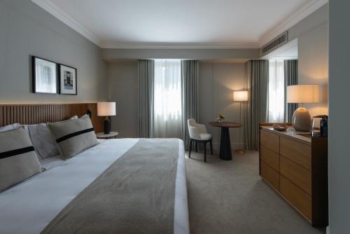 ブエノスアイレスにあるHotel Casa Luciaの大きなベッドとデスクが備わるホテルルームです。