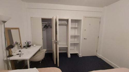 a white room with a desk and a mirror at Sandfield Private Rooms in King's Cross St Pancras in London
