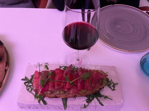 a plate of food on a table with a glass of wine at Woodside Kopaonik & SPA by Slopeview in Kopaonik