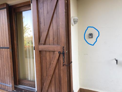 una puerta de madera abierta con una flecha azul en la pared en Loft in Saillagouse, en Saillagouse