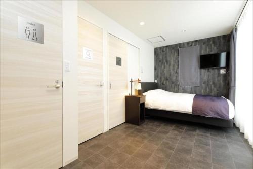 a bedroom with a bed and a sliding door at CHA-AN UENO Hotel Ueno - Vacation STAY 74227v in Tokyo