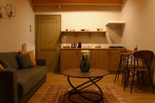 a living room with a couch and a table and a kitchen at Δρυάδες Suites 2 in Arachova