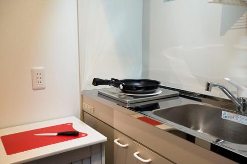 a kitchen with a sink and a pan on a stove at CHA-AN UENO Hotel Ueno - Vacation STAY 74227v in Tokyo