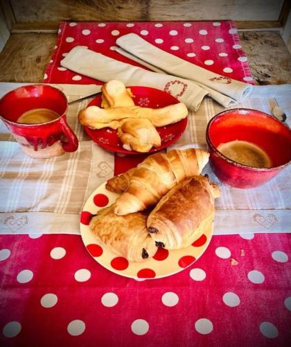 une table avec une assiette de pain et deux tasses de café dans l'établissement Le mazot d'H, à Entremont