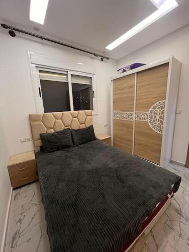 Un dormitorio con una cama grande y una ventana en blue city apartment 1, en Chefchaouen