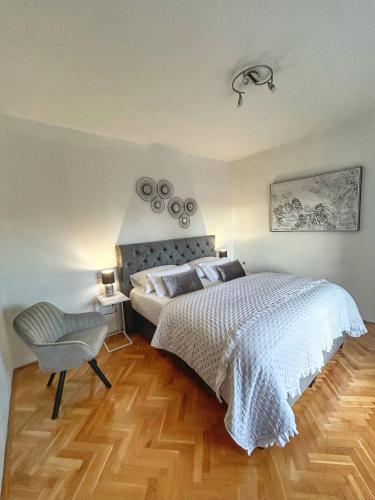 ein Schlafzimmer mit einem großen Bett und einem Stuhl in der Unterkunft Apartment Dario in Zadar