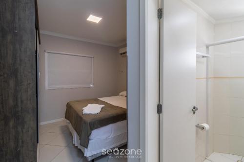 a small bedroom with a bed and a shower at Apto c/ varanda 600m da orla Centro BC EJF0702 in Balneário Camboriú
