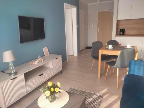 a living room with a television and a table and chairs at Apartament Nawigator Rybacka 12 b/59 in Kołobrzeg