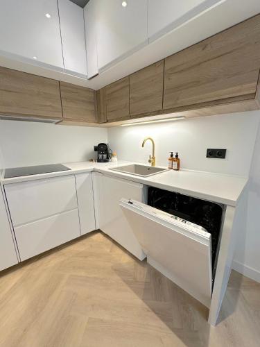 une cuisine blanche avec un évier et un lave-vaisselle dans l'établissement MONACO # MENTON - 6 PERSONS - 2 BEDROOMS - FULL RENOVATED - PRIVATE PARKING - FULL CLIM - HYPERCENTER - BEACH AND SUn, à Menton