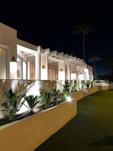 a night view of a building with palm trees at Reyes Católicos Premium Beach, Playa Urbanova, Alicante in Alicante