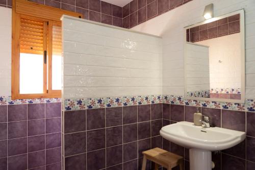 uma casa de banho com um lavatório e um espelho em Namawa Surfhouse em Chiclana de la Frontera