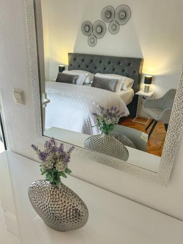 a bedroom with a large mirror on a table with flowers at Apartment Dario in Zadar