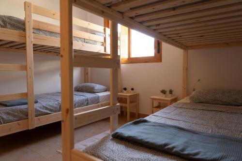 1 dormitorio con 2 literas y ventana en Namawa Surfhouse en Chiclana de la Frontera