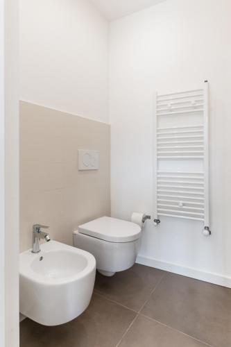 a white bathroom with a toilet and a sink at Terrazza Dei Sogni in Ragusa