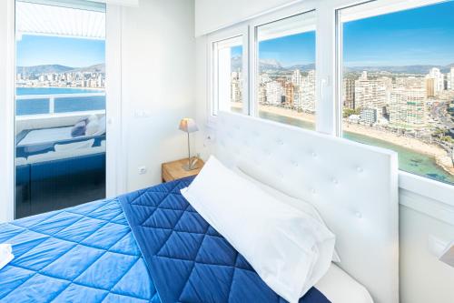 ein Schlafzimmer mit einem Bett und einem großen Fenster in der Unterkunft Gemelos 28-16D Deluxe Apartment Levante Beach in Benidorm