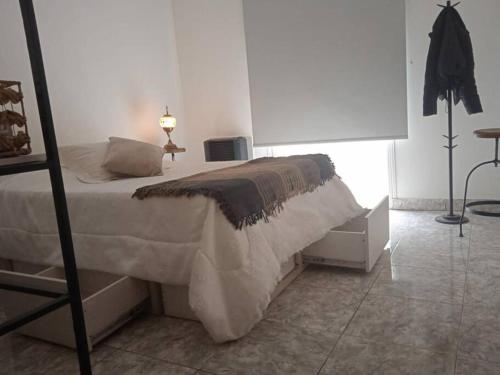 里奧格蘭德的住宿－Departamento equipado Río Grande，一间卧室配有一张床、一盏灯和一张桌子