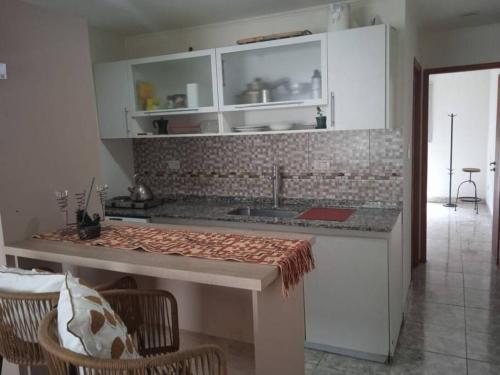 a kitchen with white cabinets and a counter top at Departamento equipado Río Grande in Río Grande