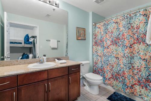 een badkamer met toilet en douchegordijn bij Nautical Nest at Laketown Wharf #1019 by Nautical Properties in Panama City Beach