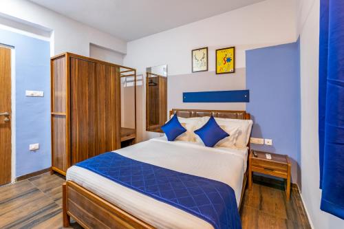 1 dormitorio con 1 cama grande y paredes azules en Smart Stay by Isthara Vega. Kondapur en Kondapur