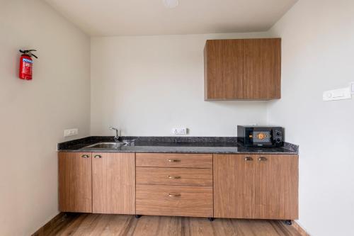 a kitchen with a sink and a microwave at Smart Stay by Isthara Vega. Kondapur in Kondapur