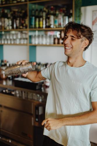 a man standing at a bar holding a machine at HEJMO in Hossegor