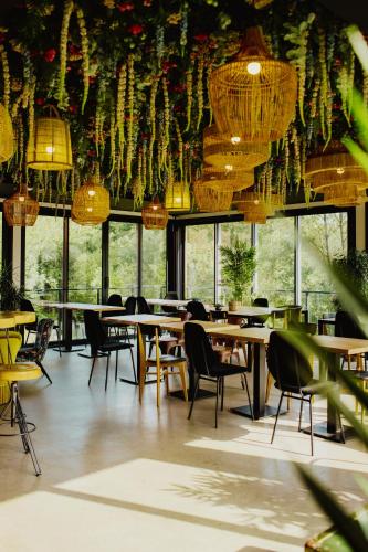 a restaurant with tables and chairs and chandeliers at HEJMO in Hossegor