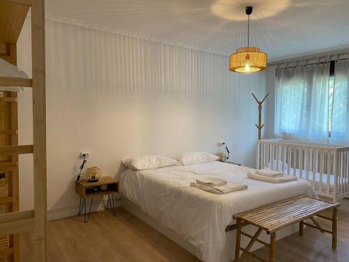 Dormitorio blanco con cama y mesa en La Casina de Rodiles en Liñero