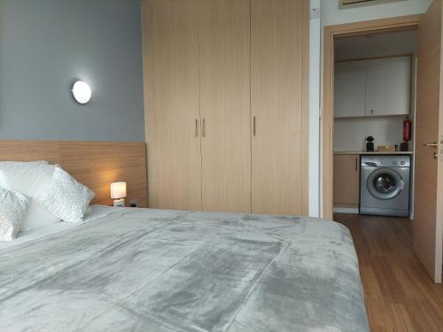 a bedroom with a large bed and a washing machine at Milepost vacations in Paralimni