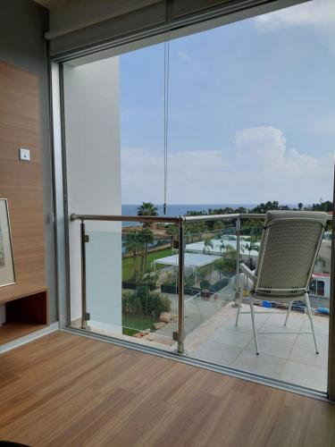 a chair on a balcony with a view of the ocean at Milepost vacations in Paralimni