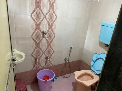 Baño pequeño con aseo y lavamanos en Royal Devbaug Holiday Home, en Malvan