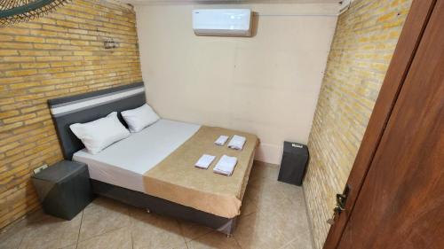 a small bedroom with a bed and a brick wall at Aregua 1077 in Asunción