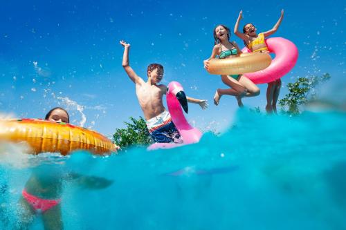 a group of people in the water on inflatables at Beautiful Caravan With Decking At Trevella Holiday Park, Newquay, Ref 98082hs in Newquay