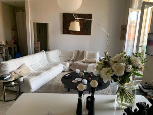 - un salon avec un canapé blanc et une table fleurie dans l'établissement CANNES DUPLEX CROISETTE FESTIVAL 5 et 6 VOYAGEURS, à Cannes