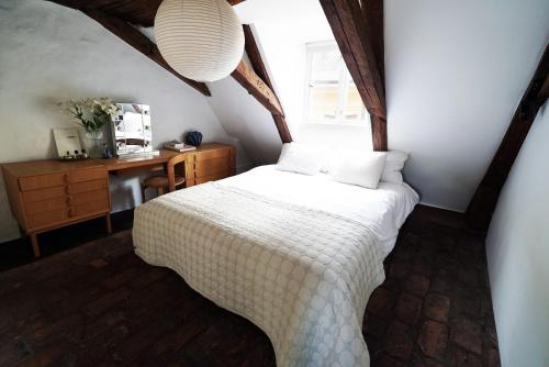 a bedroom with a bed and a desk and a window at The architects' house in Stockholm