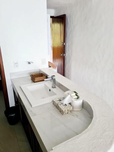 a white bathroom with a sink and a mirror at Hotel los tules 12-501 in Puerto Vallarta