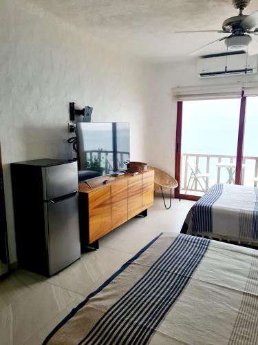 a bedroom with a dresser with a television and a bed at Hotel los tules 12-501 in Puerto Vallarta